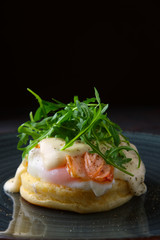 Sandwich with poached egg, smoked salmon and cheese decorated with arugula