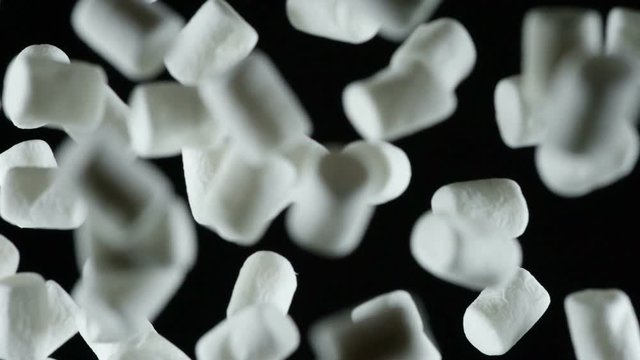 Appetizing Little Marshmallow. A large number of light marshmallow flies into the frame of the darkness. Filmed at a speed of 480fps