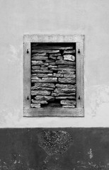 A window in a derelict building in the Croatian hill village of Bale, also called Valle. The window has been blocked with stones