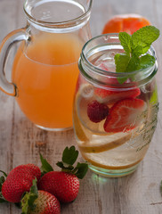 Fresh drink with strawberries, lemon and mint. Serving on a wooden table
