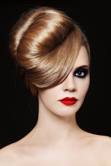 Portrait of young beautiful woman with smoky eye make-up and prom hairdo