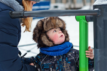 child in winter in the yard on the Playground