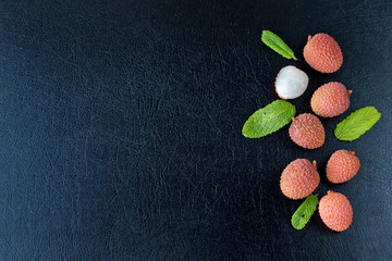 fresh organic lychee fruit on black background, top view