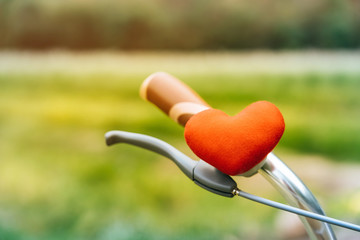  A little red heart pillow on the bicycle handlebar.