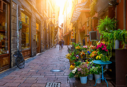 Fototapeta Old narrow street with flower shop in Bologna, Emilia Romagna, Italy