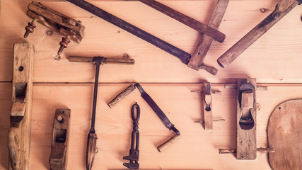 The horizontal photo of the old tools on the wooden wall. Scenery. Antique Decorative Tools