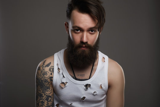 man with beard. Boy with stylish haircut and tattoo