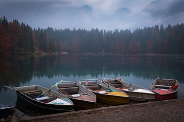 Five colorful boats on evening in lake Laghi di Fusine