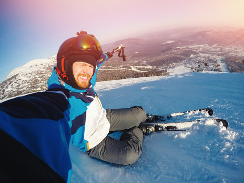 Selfie Guy sportsman goes on normal skiing on ski slope with action camera. Sunset. winter