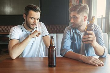 men drinking beer in cafe together
