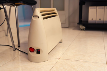 Portable heater in small office. Heating device.