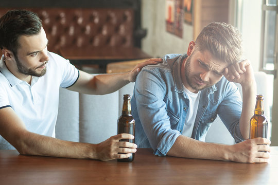 man drinking beer his friend in cafe