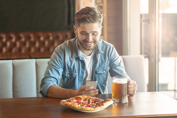 man sitting in cafe using smartphone