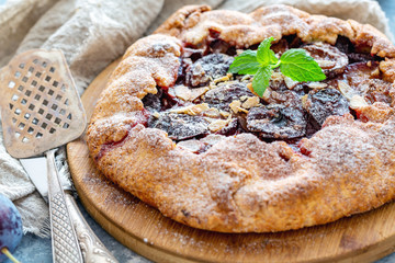 Fruit pie with plums,almond flakes and mint.