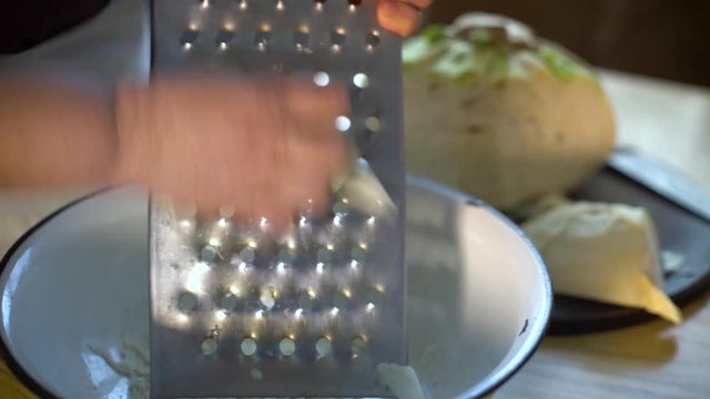 Closeup of senior woman hands grating cabbage
