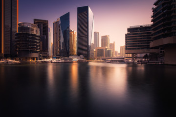 Obraz premium Beautiful view to Dubai Marina Promenade, UAE. Long exposure time lapse effect at sunset