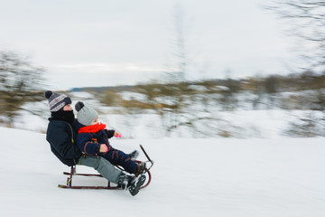 Small boy sledding at winter time. Motion blur