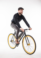 Portrait of a hipster beard man riding on bicycle over gray background