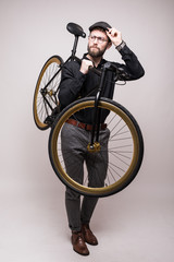 Portrait of a smiling casual man holding bicycle on the shouder over white background