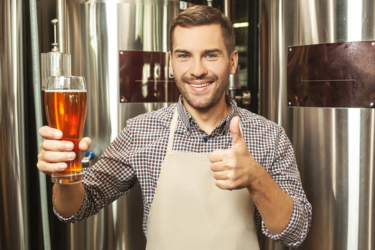 worker holding glass of beer - Powered by Adobe