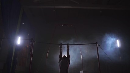 Gymnast exercises on high horizontal bar HD slow-motion video. Athlete training gymnastics skills and performing giant elements