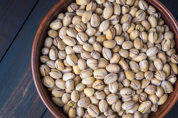 Pistachios in a clay bowl.