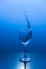 Water splash out of a wine glass.