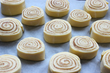 Beautiful fresh cinnamon rolls. The cooking process. Fresh fragrant pastries. Raw dough for buns.Close up.