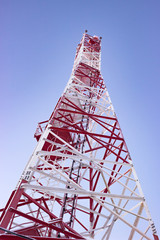 White-red cell tower or mobile tower on blue sky shot from bottom 