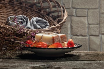 couple bars of handmade soap on oriental plate with several fruits of physalis