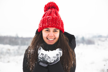 woman in red hat with bubo holding snow in hands