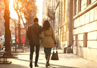 Dreamy couple carefree walking on street of old city at sunset