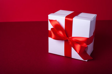 Gift box on red background. Valentine day, woman day gift. Red and white. ribbon, band.