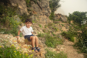 Naklejka premium boy sitting on the rock