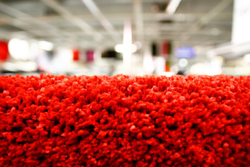 Close up of a fragment of red carpet in a bright shop.