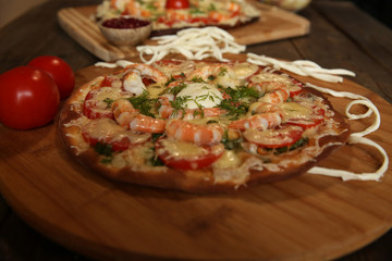 seafood pizza, shrimp and mozzarella cheese on a wooden table close-up