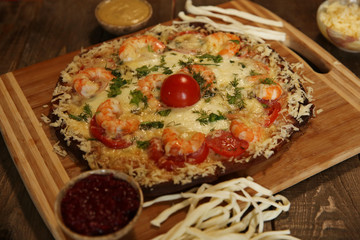 seafood pizza, shrimp and mozzarella cheese on a wooden rustic table  close-up
