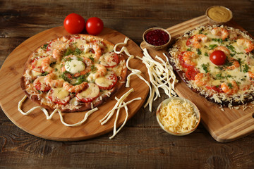 Two seafood pizza, shrimp and mozzarella cheese on a wooden rustic table with space for text