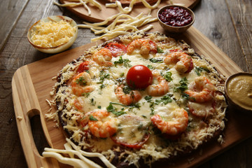 Seafood pizza, shrimp and mozzarella cheese on a wooden rustic table