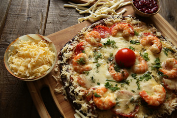 Seafood pizza, shrimp and mozzarella cheese on a wooden rustic table
