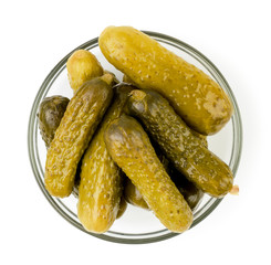 Marinated cucumbers in a plate on a white. The form of the top.
