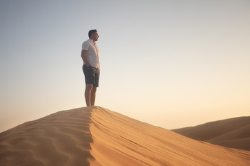 man standing on sand dune