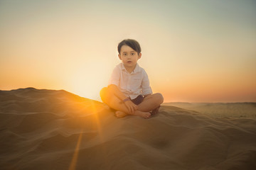 boy sitting on the sand