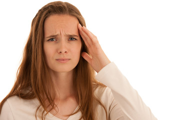 Beautiful young brunette woman holds her head as she has headache - illness