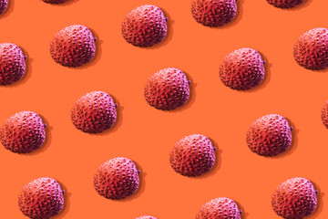 Lychee fruits colorful pattern on a orange background. Tropical fruits concept. Flat lay. Top view.
