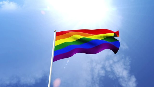 The LGBT pride flag of waving in the wind on a sunny day.  Beautiful slow motion shot of the Rainbow flag.
