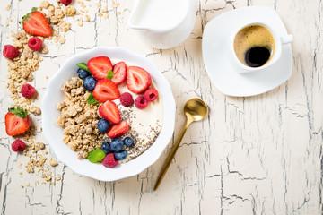Breakfast granola with berries, yoghurt and coffee. Cereal oats with strawberries, blueberries and raspberries for healthy eating. Top view
