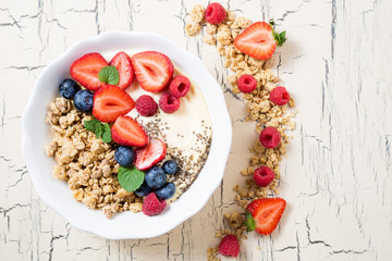 Breakfast with granola with berries, yoghurt and fruits. Cereal oatmeal with strawberries, blueberries and raspberries. Muesli with fruits and berries. Dieting, healthy food concept