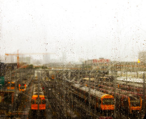Looking through scratched window with raindrops at trains parked on tracks near Brisbane Australia
