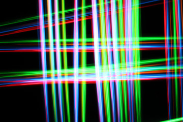 A colorful and glowing light painting abstract image with red, green, blue and yellow blurry lines over a black background, creating a net